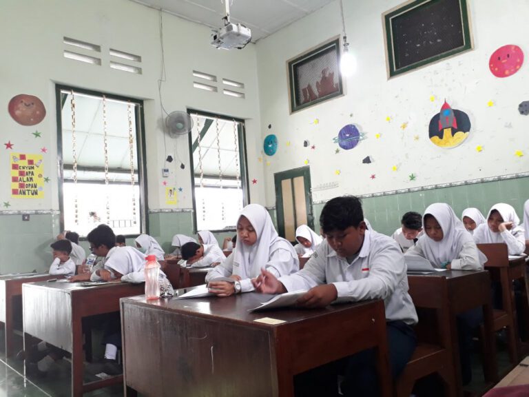 Siswa mengerjakan penilaian di ruang kelas